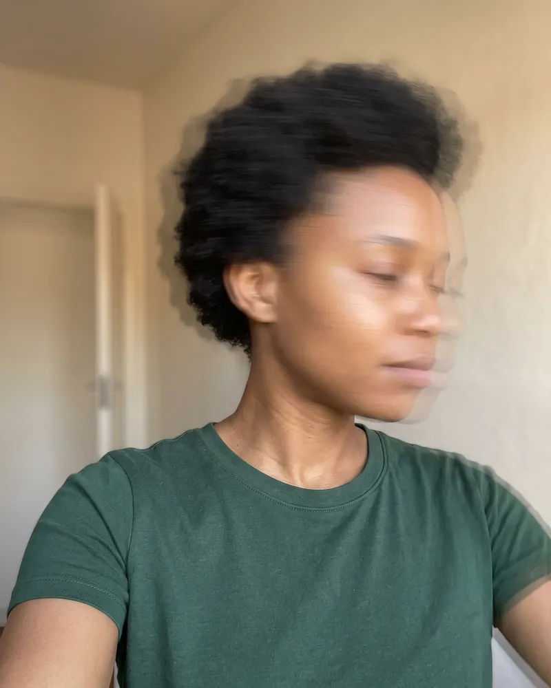 The same woman turning her head quickly, the whole photo smeared by motion blur.